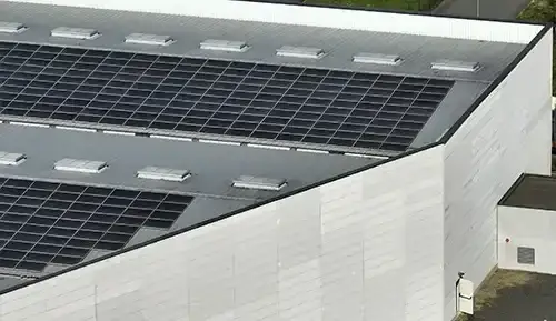 Rows of solar panels integrated across the roof of a modern commercial building