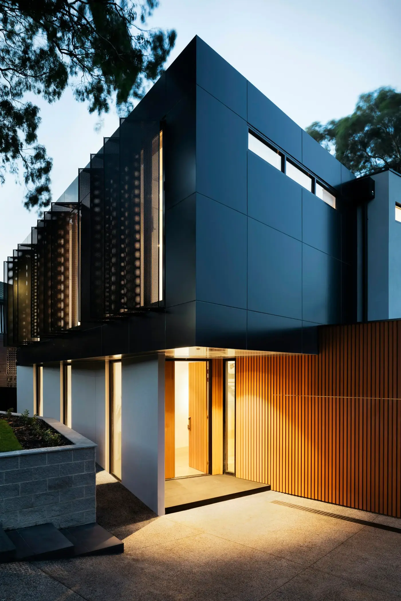 Modern residential home exterior with a clean roofline and landscaped yard