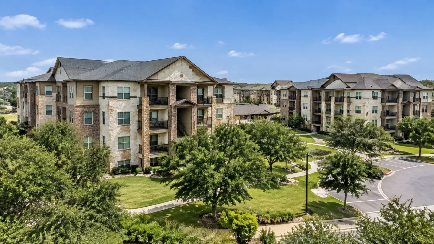 Large multi-family residential complex with recently completed roofs and landscaped grounds